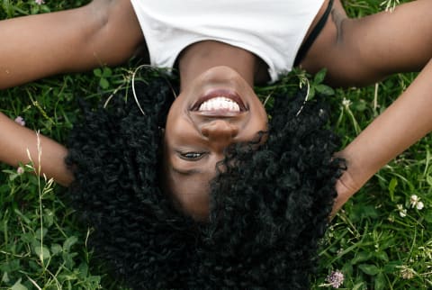 girl with curls laying down in the grass