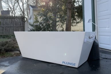 Plunge cold plunge tub on driveway at tester home with trees in background